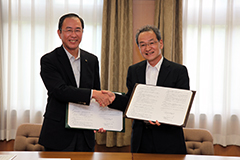 握手を交わす古山正雄学長（右）と日新電機(株) 小畑英明社長（左） 