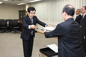 採択決定通知書を受け取る熊田准教授