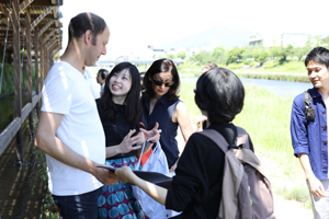鴨川納涼床でヘルツ教授、ラーバラン氏と学生が議論する様子
