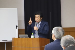 講演をする日高一樹 特任教授