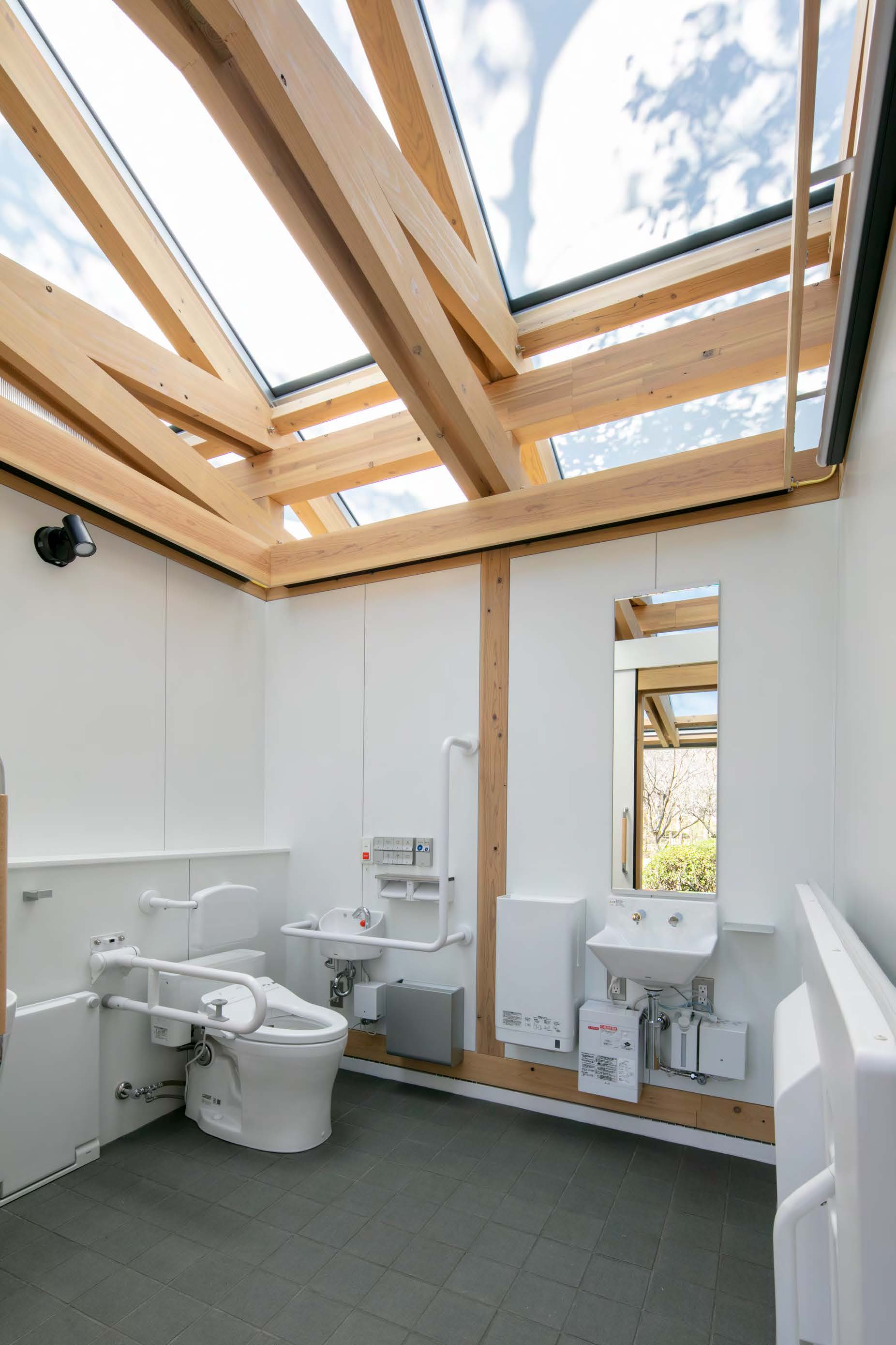 木陰が頭上で揺らぐ爽やかなトイレ内部